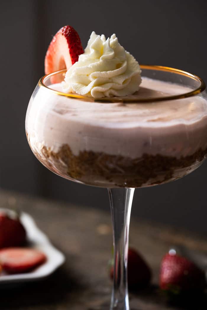 Keto strawberry cheesecake in a tall glass with whipped cream