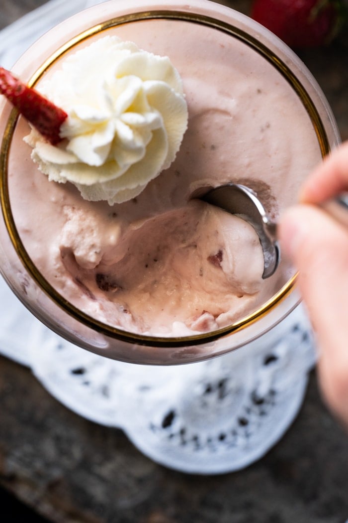 Eating strawberry cheesecake with a dessert spoon