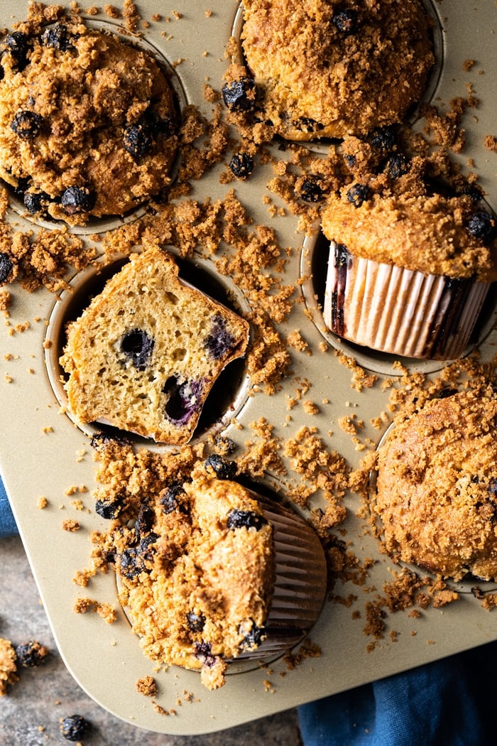 Freshly baked low carb blueberry muffins in tray with scattered streusel