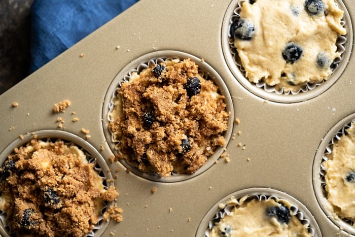 Adding streusel to unbaked keto blueberry muffin batter