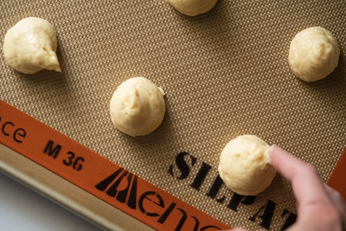 Smoothing out the keto donut dough on a baking mat