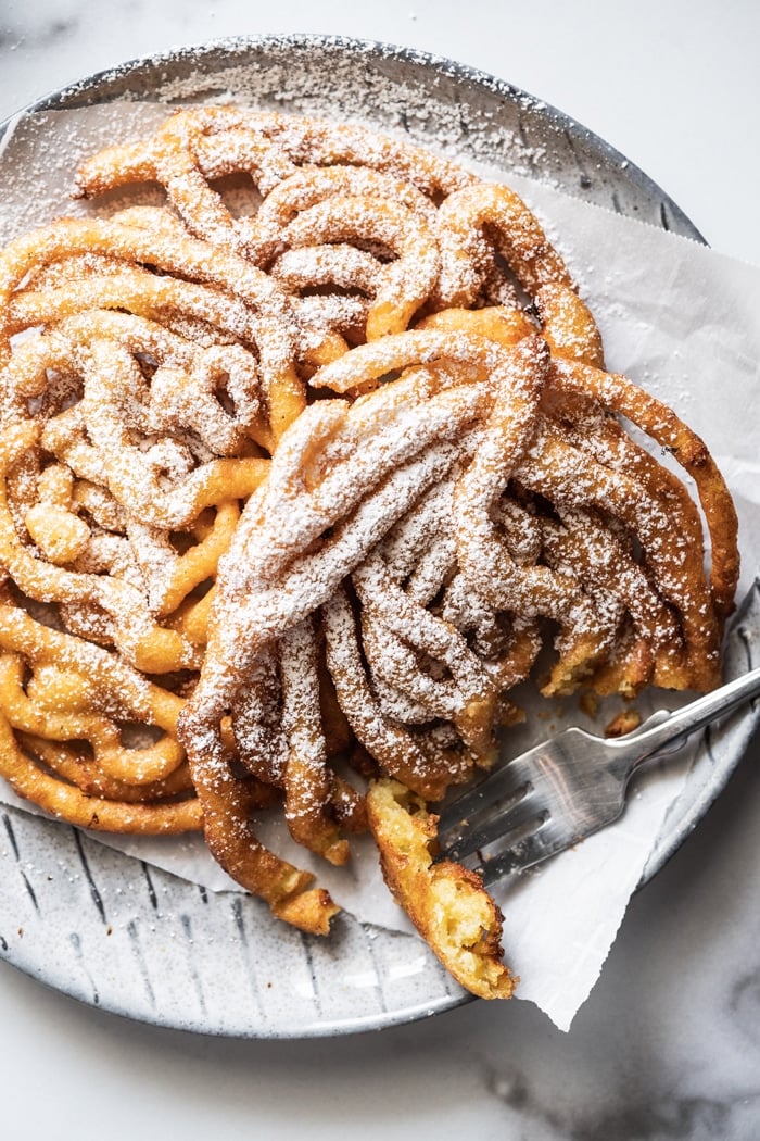 Eating gluten free funnel cakes with a fork