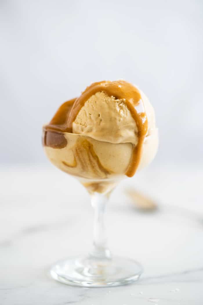 Keto caramel ice cream with caramel sauce dripping on top