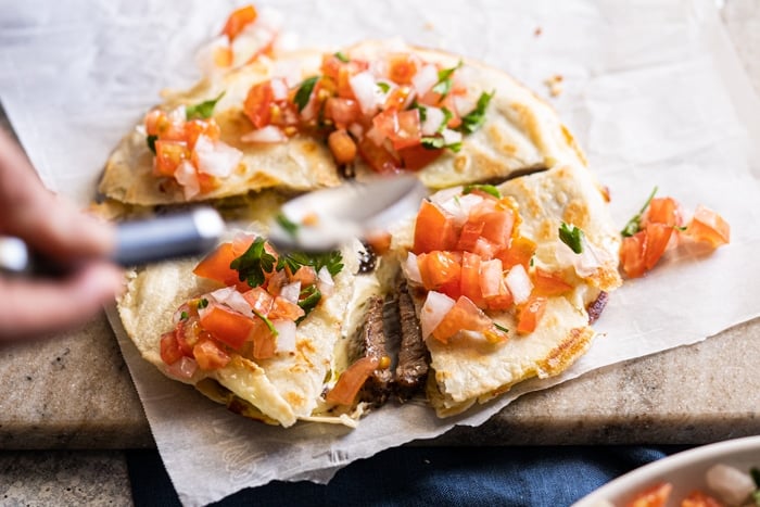 Topping the keto quesadillas with pico de Gallo salsa