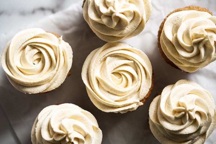 Keto cream cheese buttercream frosting piped unto vanilla cupcakes