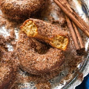 Halved keto apple cider donuts rolled in cinnamon sugar coating