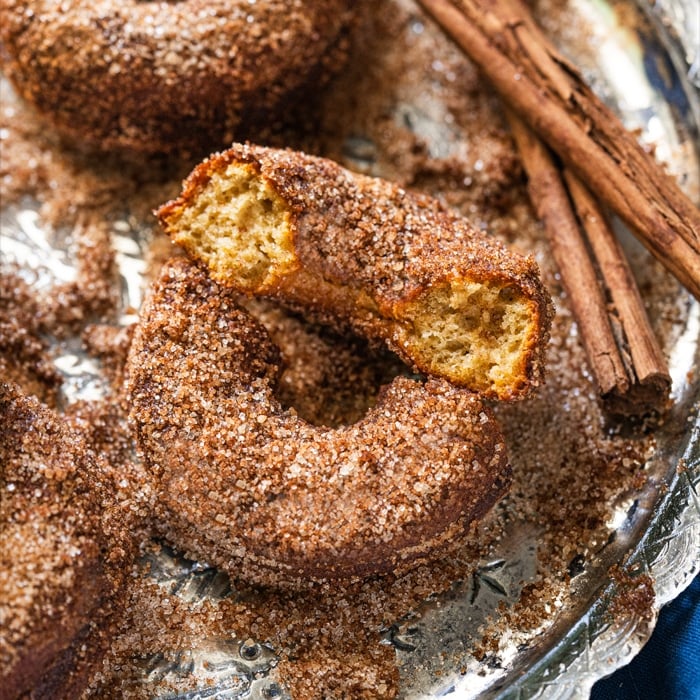 Halved keto apple cider donuts rolled in cinnamon sugar coating