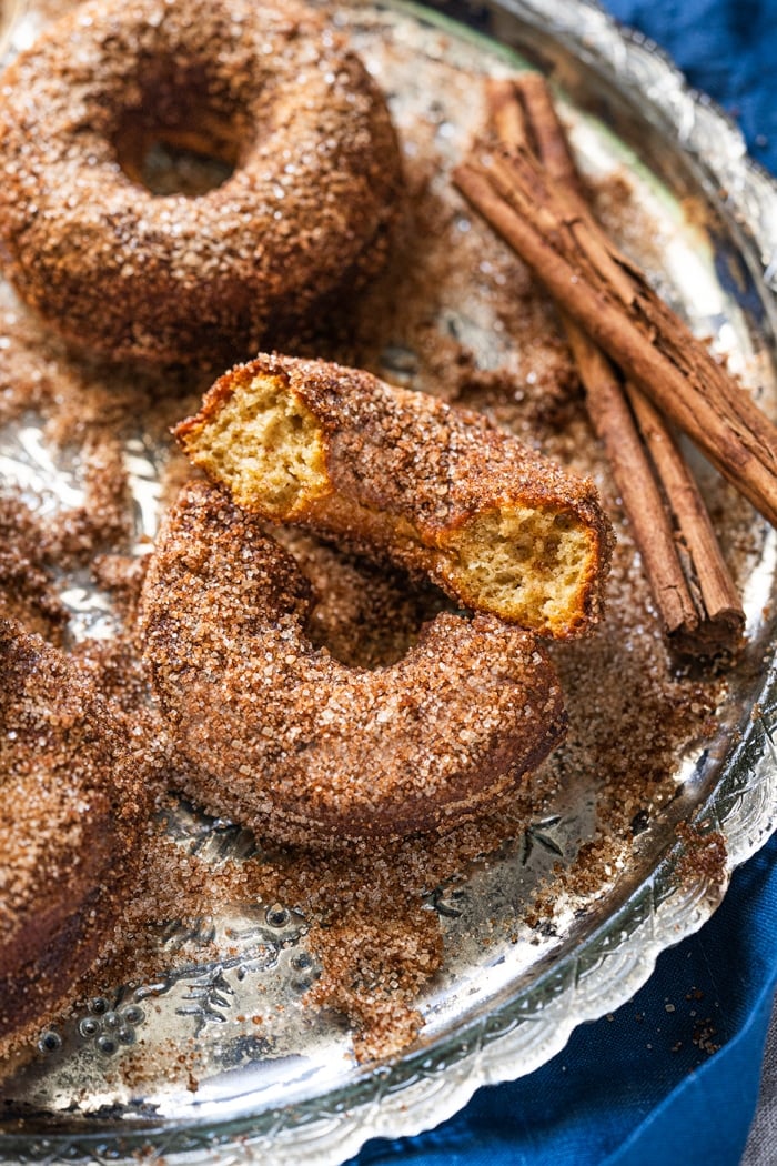 Halved keto apple cider donuts rolled in cinnamon sugar coating