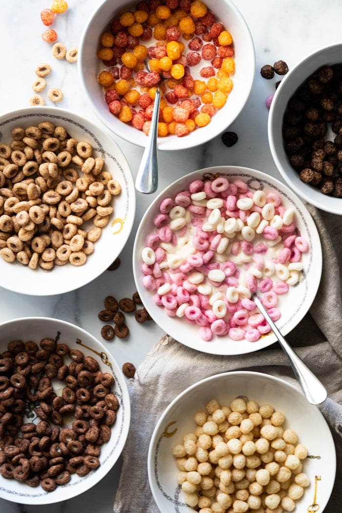 Six bowls of store bought keto cereal with various flavors