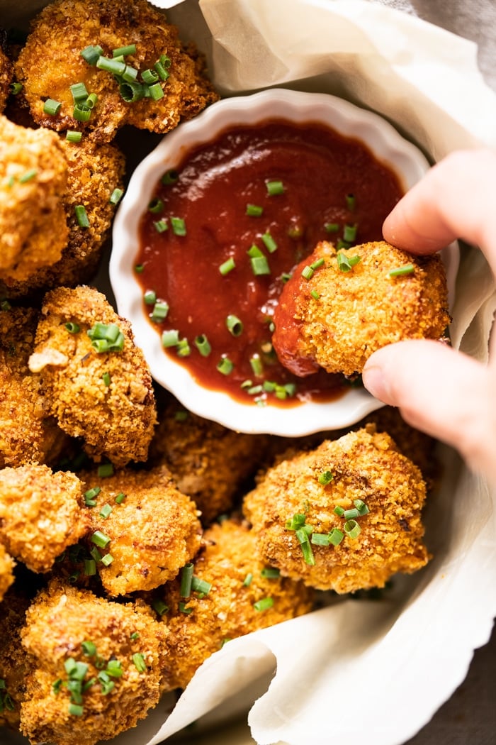 Dipping a keto chicken nugget in sugar free ketchup