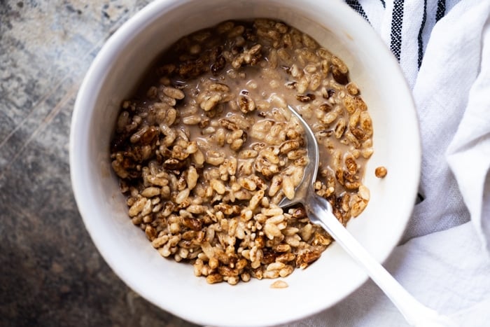 High key chocolate Keto Cereal with almond milk in a white bowl