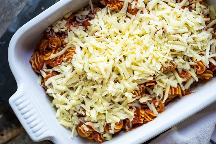 Adding grated mozzarella to the Keto pasta bake