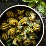 Keto pesto pasta with fresh basil and parmesan cheese in a black bowl