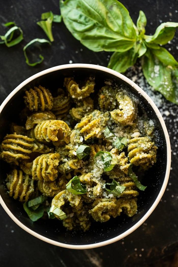 Keto pesto pasta with fresh basil and parmesan cheese in a black bowl