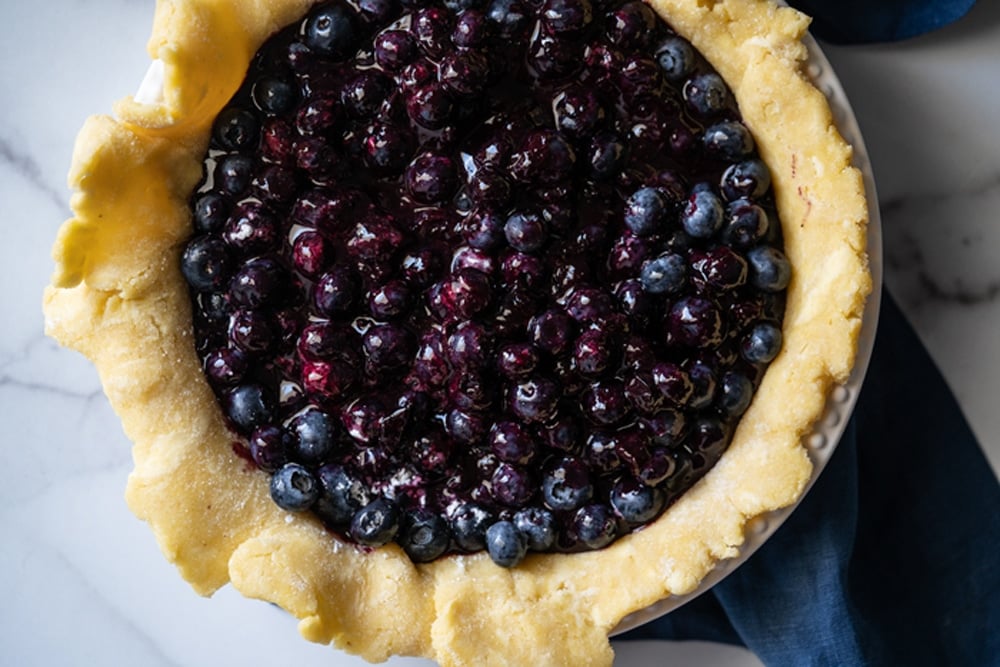 Overhead shot of unbaked Keto Blueberry pie filling, with a mix of both jam and fresh berries