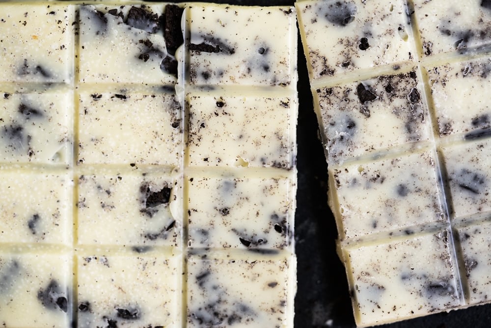 Breaking a Keto Cookies and cream candy bar in half