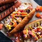 Keto hot dogs with fluffy yeast buns, pico de gallo salsa and a drizzle of mustard