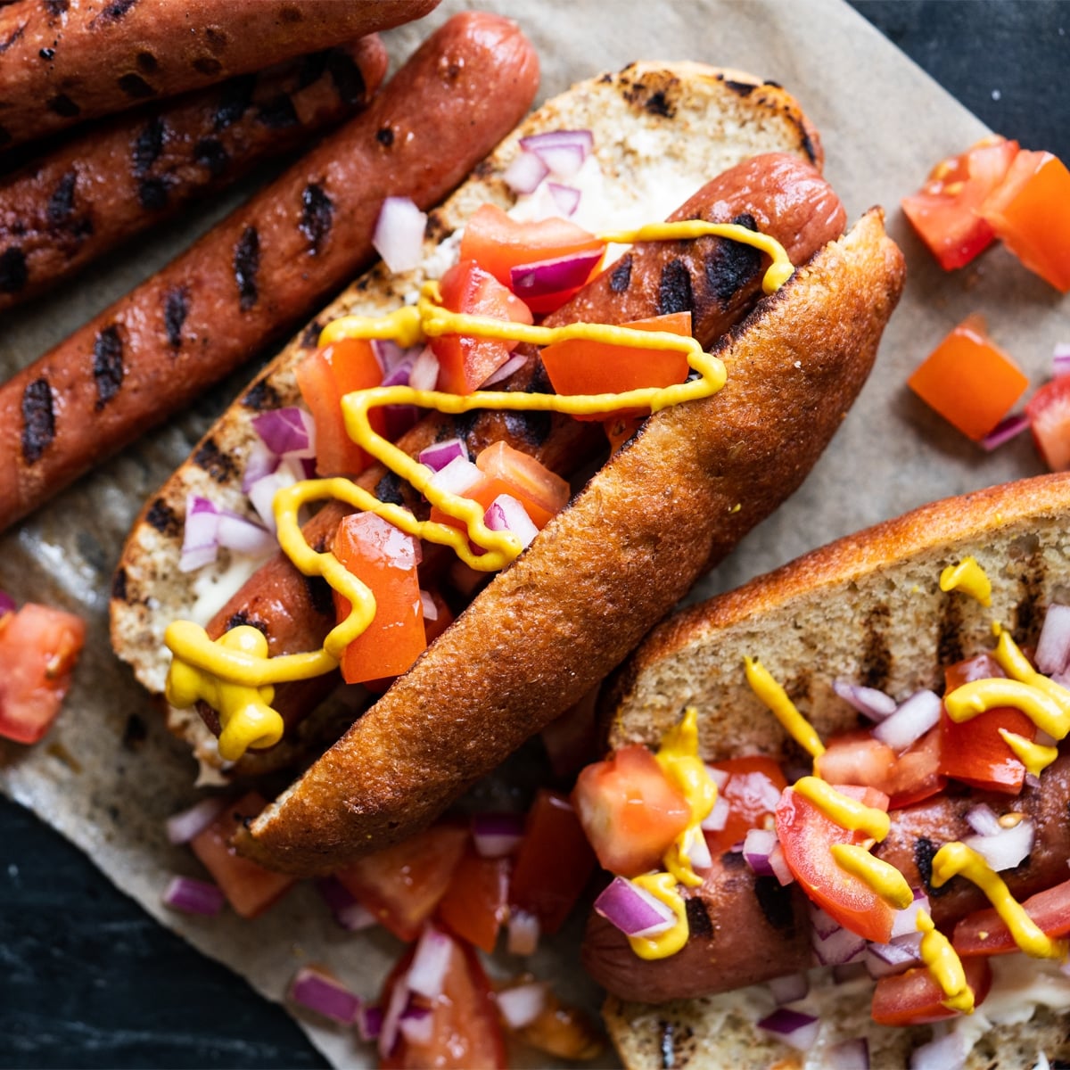 Keto hot dogs with fluffy yeast buns, pico de gallo salsa and a drizzle of mustard