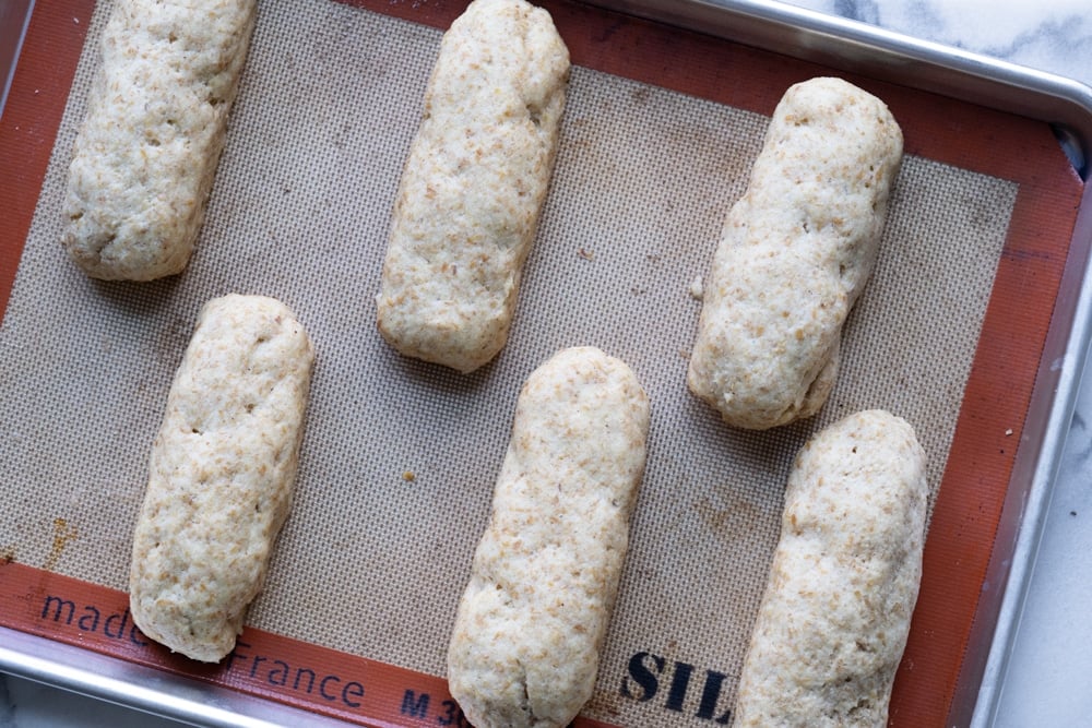 Keto hot dog buns with yeast after rise on a baking tray