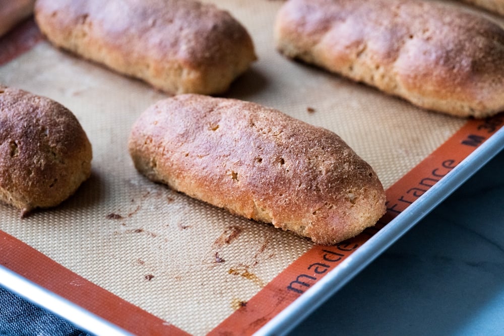 Freshly baked Keto hot dog buns on a baking tray