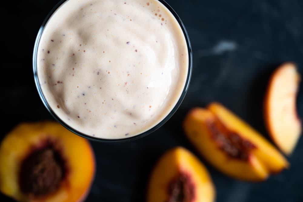 Overhead shot of a keto peach milkshake showing its luscious texture