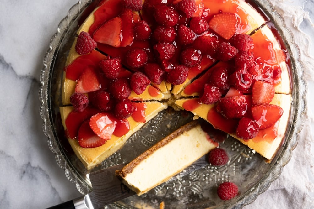 Overhead shot of a Keto Cheesecake topped with fresh berries and strawberry jelly