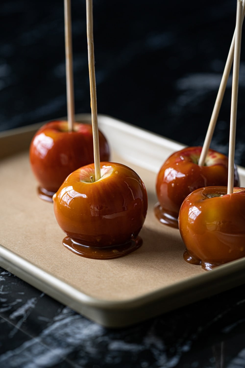 Healthy low carb caramel apples on a gold baking tray