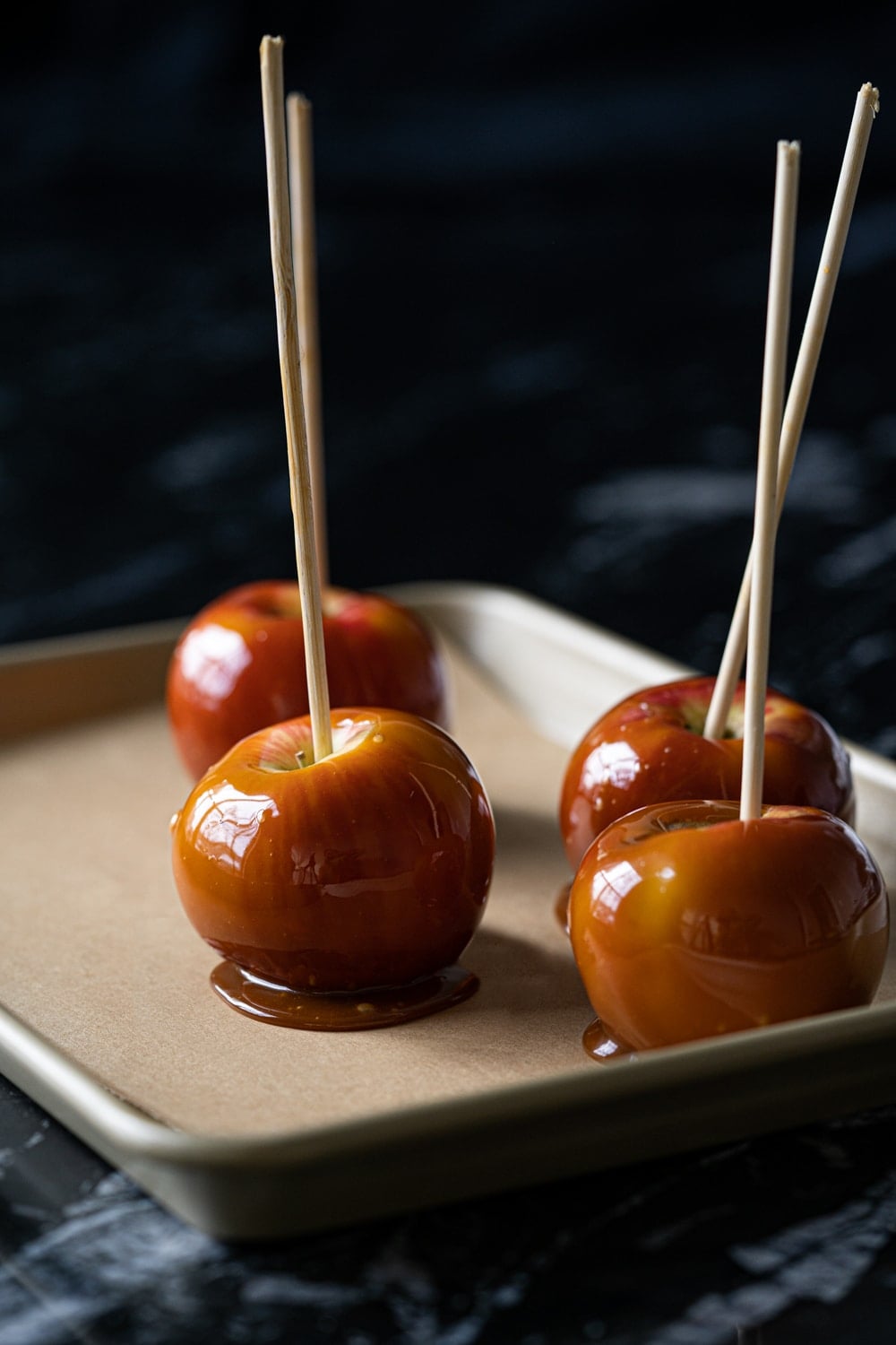 Healthy low carb caramel apples on a gold baking tray