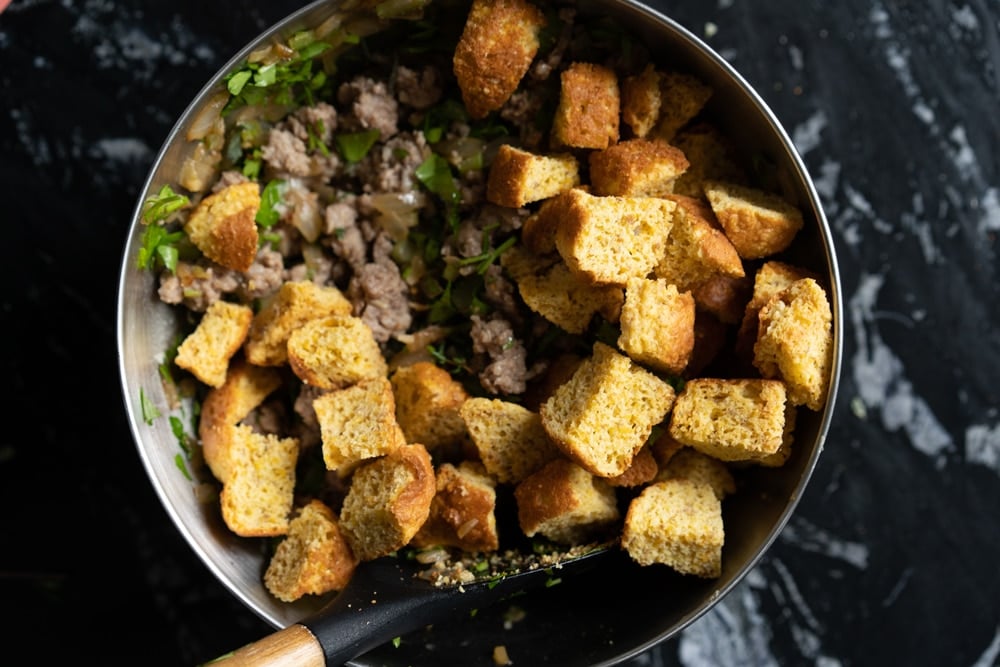Unbaked keto cornbread stuffing ingredients in a mixing bowl