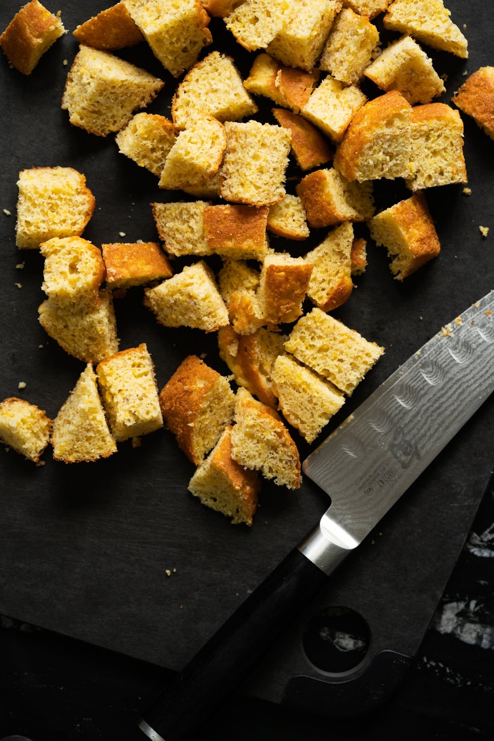 Low carb cornbread (with cornmeal!) diced on a black cutting board