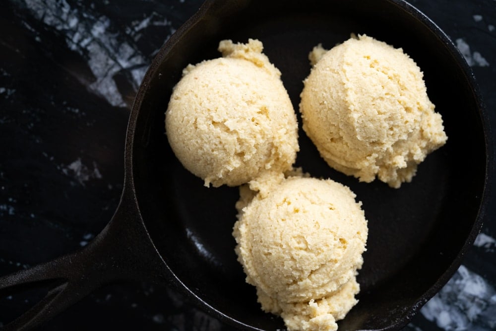 Scooping keto snickerdoodle cookie dough onto a skillet