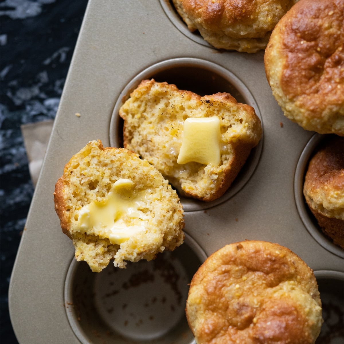 Freshly baked low carb cornbread with cornmeal and a pat of butter melting through