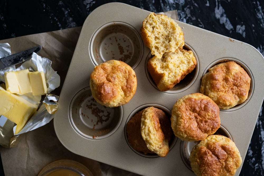 Freshly baked low carb cornbread in a muffin tin with butter 