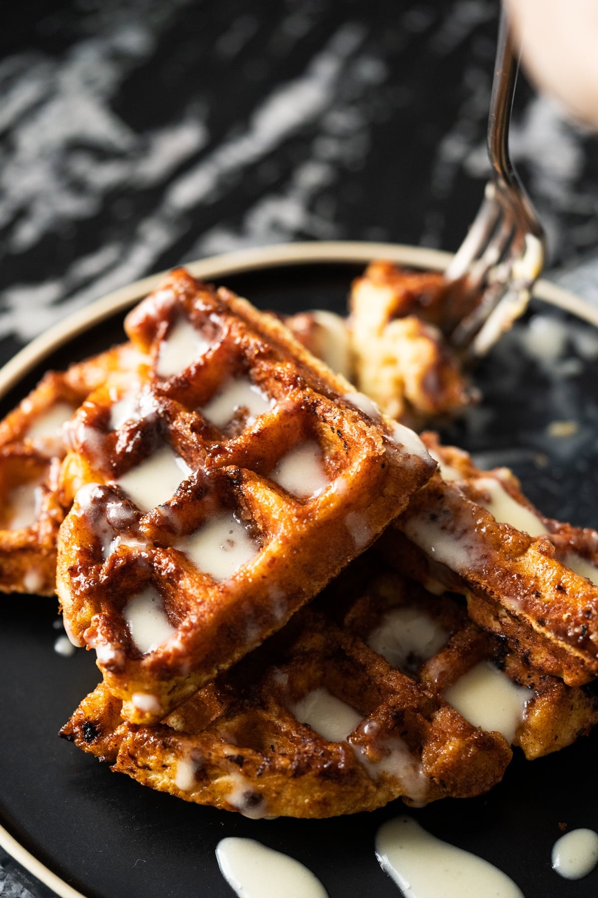Taking a piece of keto cinnamon roll waffle