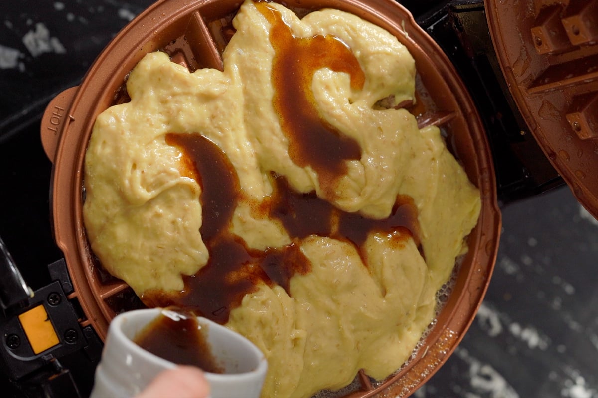 Drizzling the cinnamon sugar mixture onto the sourdough waffle batter
