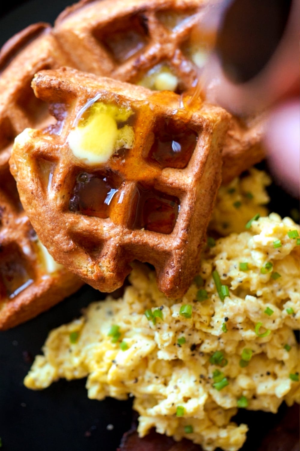 Gluten free and keto sourdough waffles with butter, sugar free syrup and a side of scrambled eggs