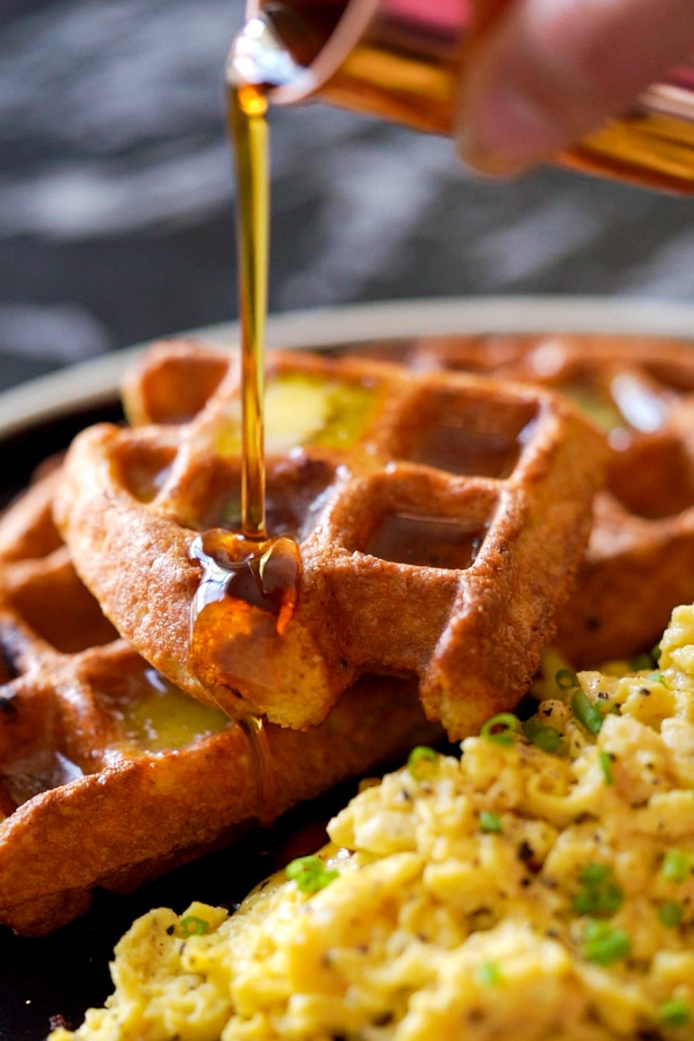 Drizzling sugar free maple syrup onto keto sourdough waffles