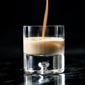 Pouring keto irish cream (i.e. a Baileys copycat!) onto a glass with ice