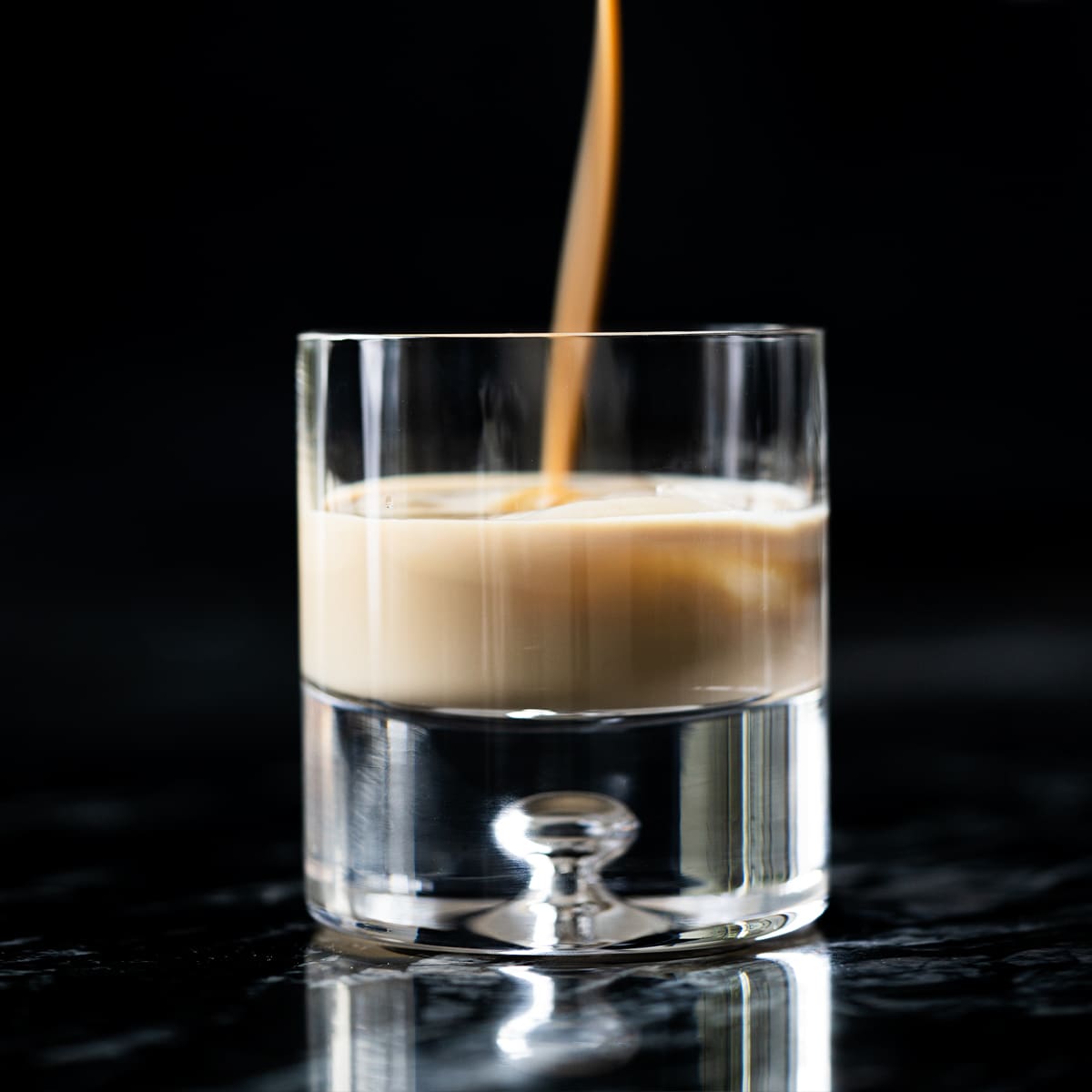 Pouring keto irish cream (i.e. a Baileys copycat!) onto a glass with ice