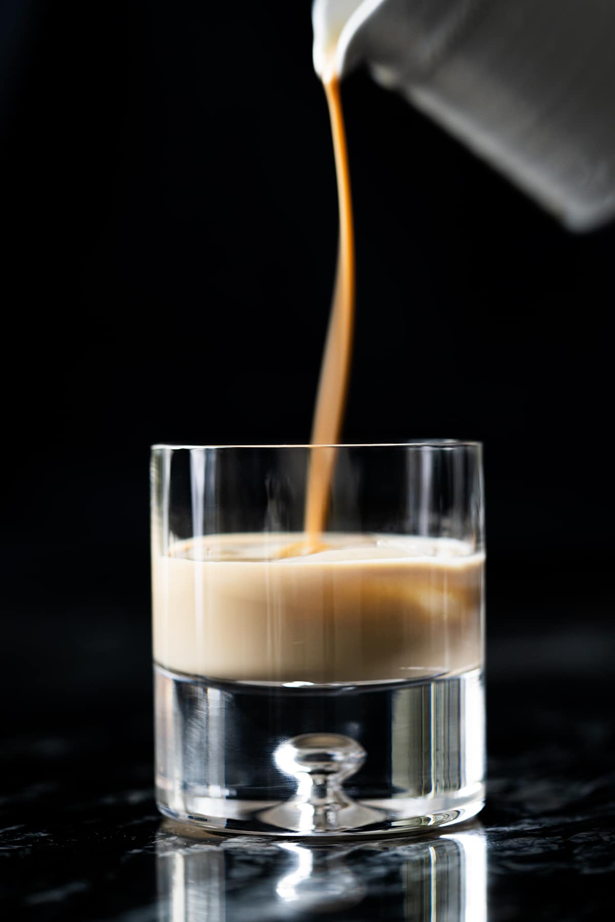 Pouring keto irish cream (i.e. a Baileys copycat!) onto a glass with ice