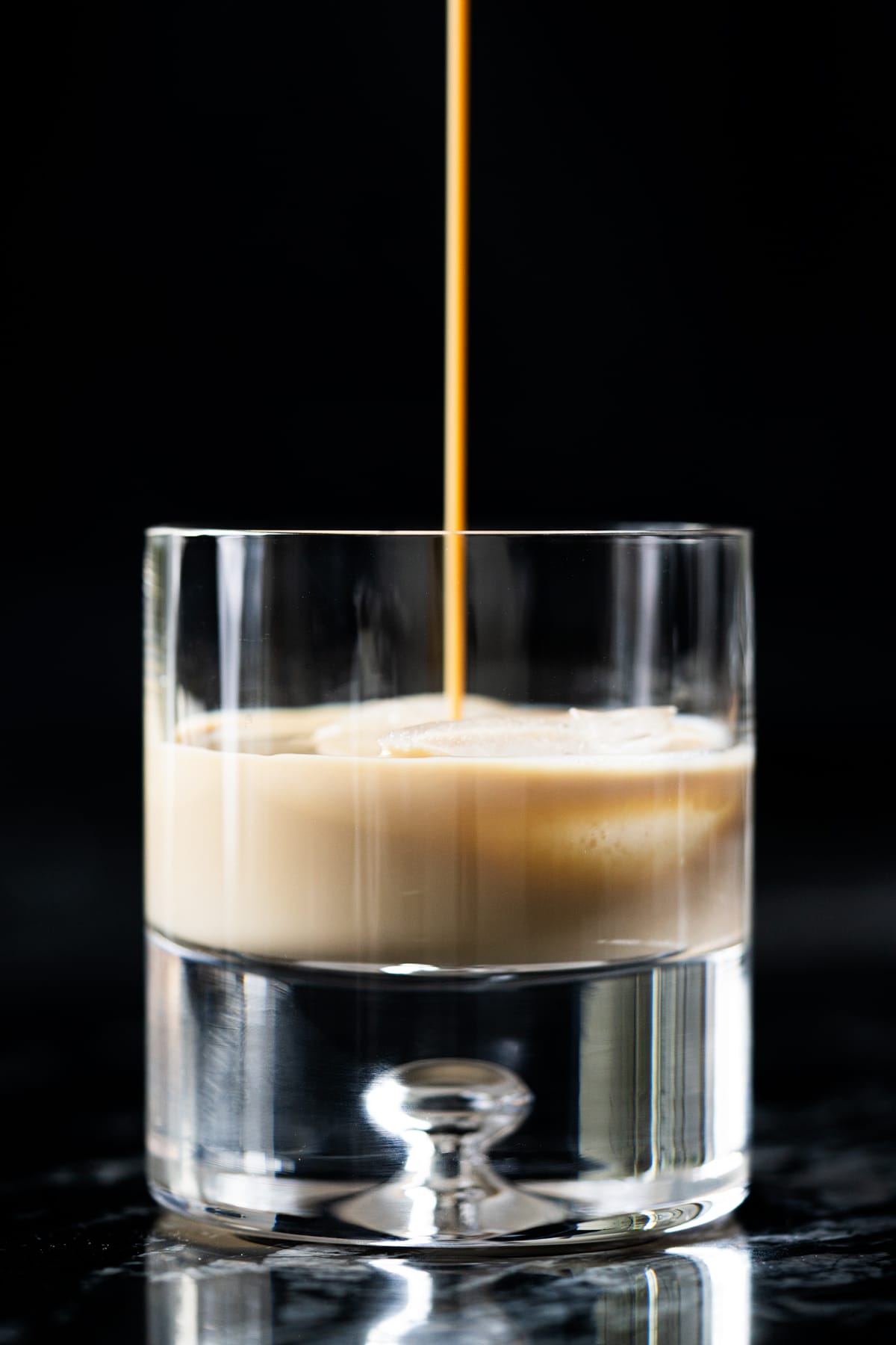 Pouring keto irish cream onto a heavy bottom glass