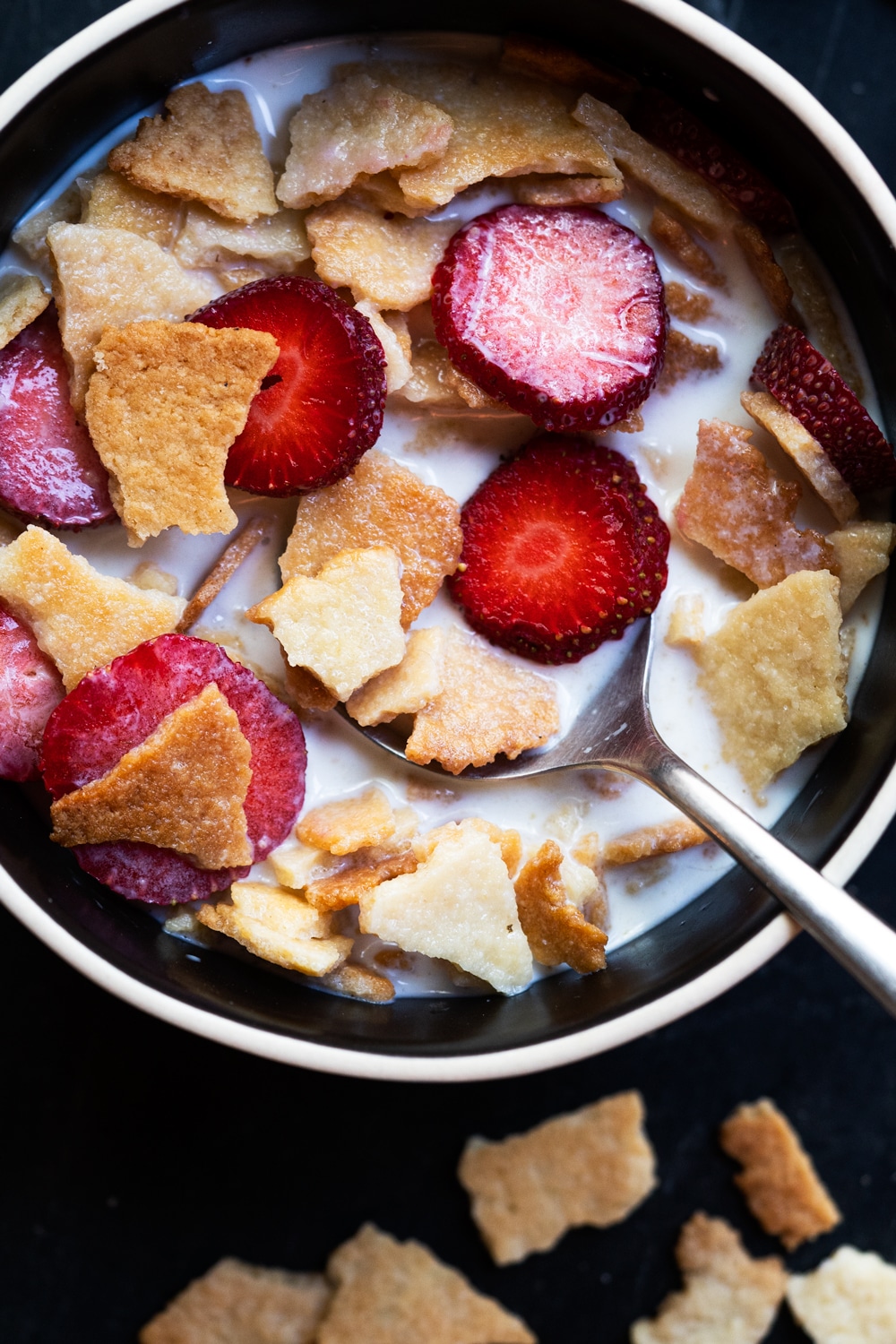 Keto cereal made with almond flour in a bowl with sliced strawberries and milk