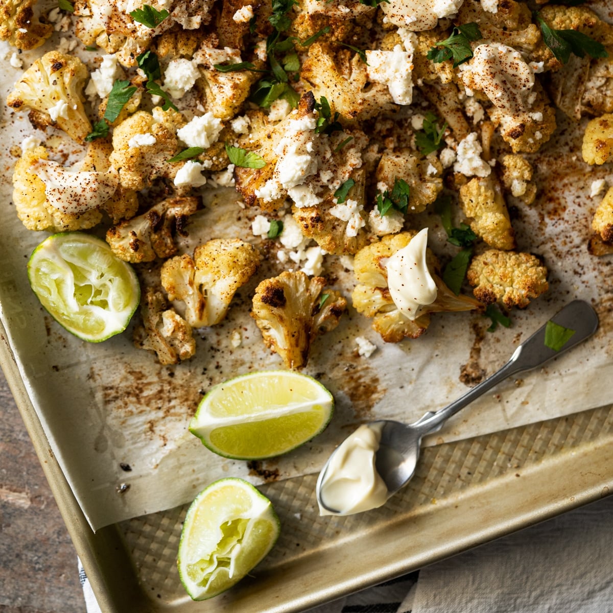 Keto Mexican street corn salad garnished with limes, queso and cream