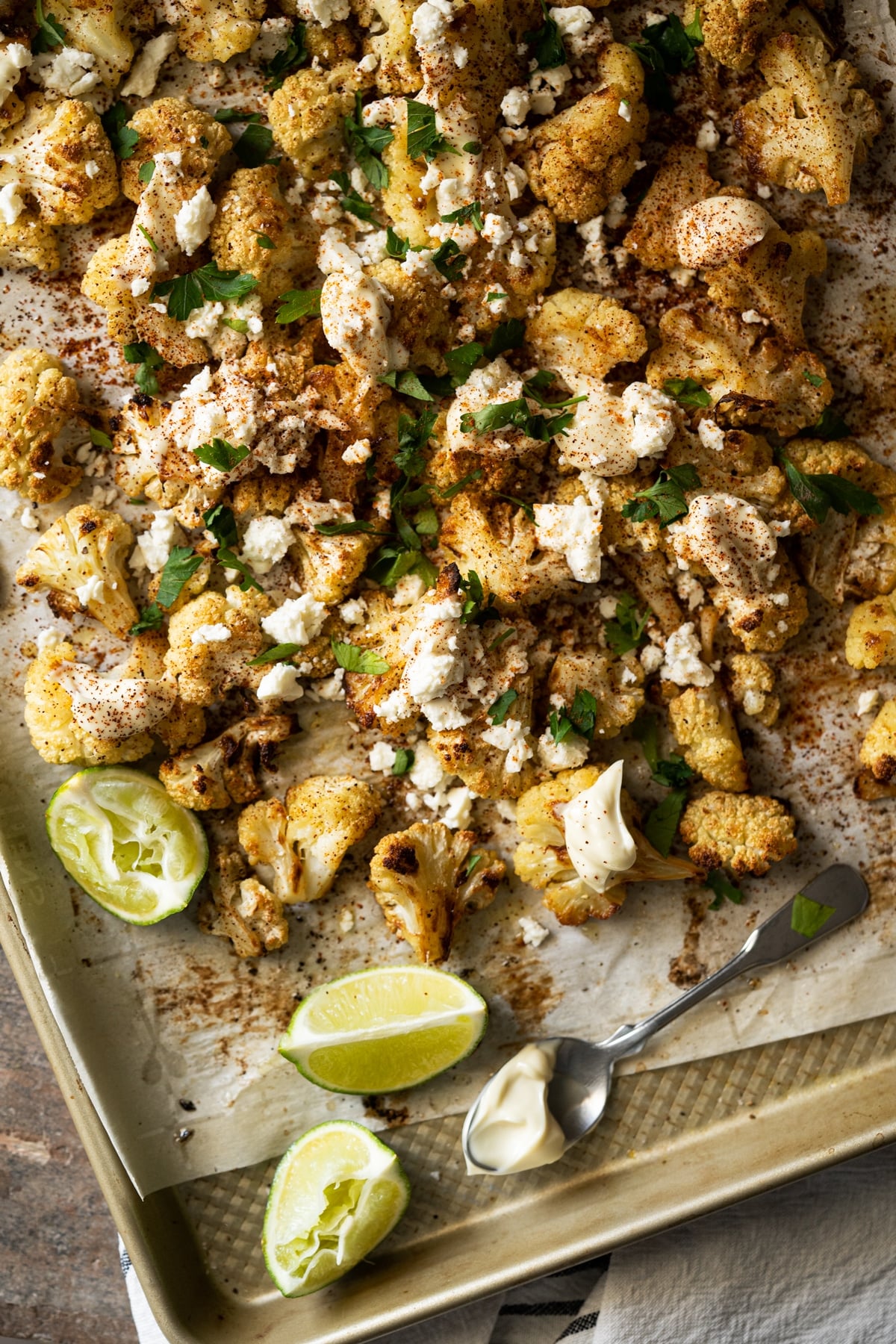 Keto Mexican street corn salad garnished with limes, queso and cream