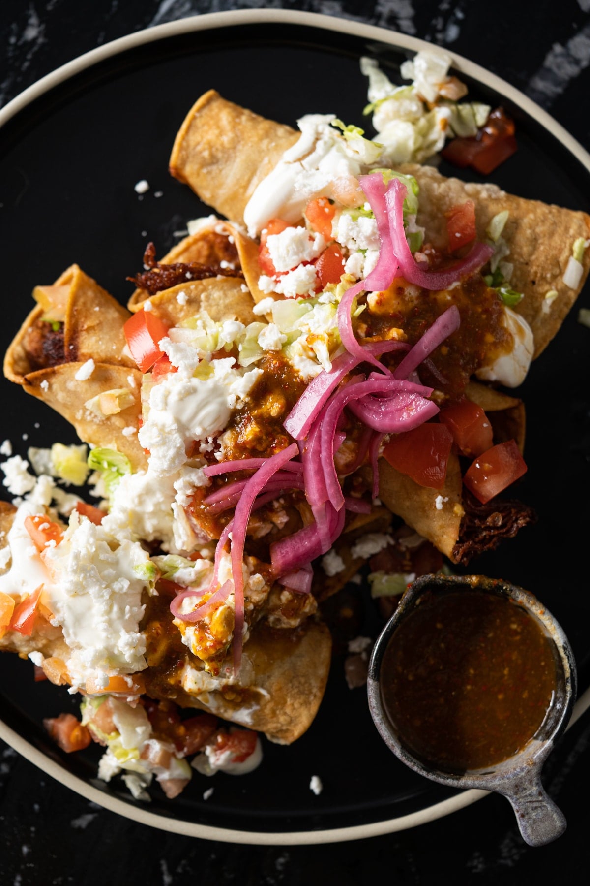Mexican chicken taquitos (i.e. flautas!) topped off with lettuce, cream, cheese, pickled onions and salsa