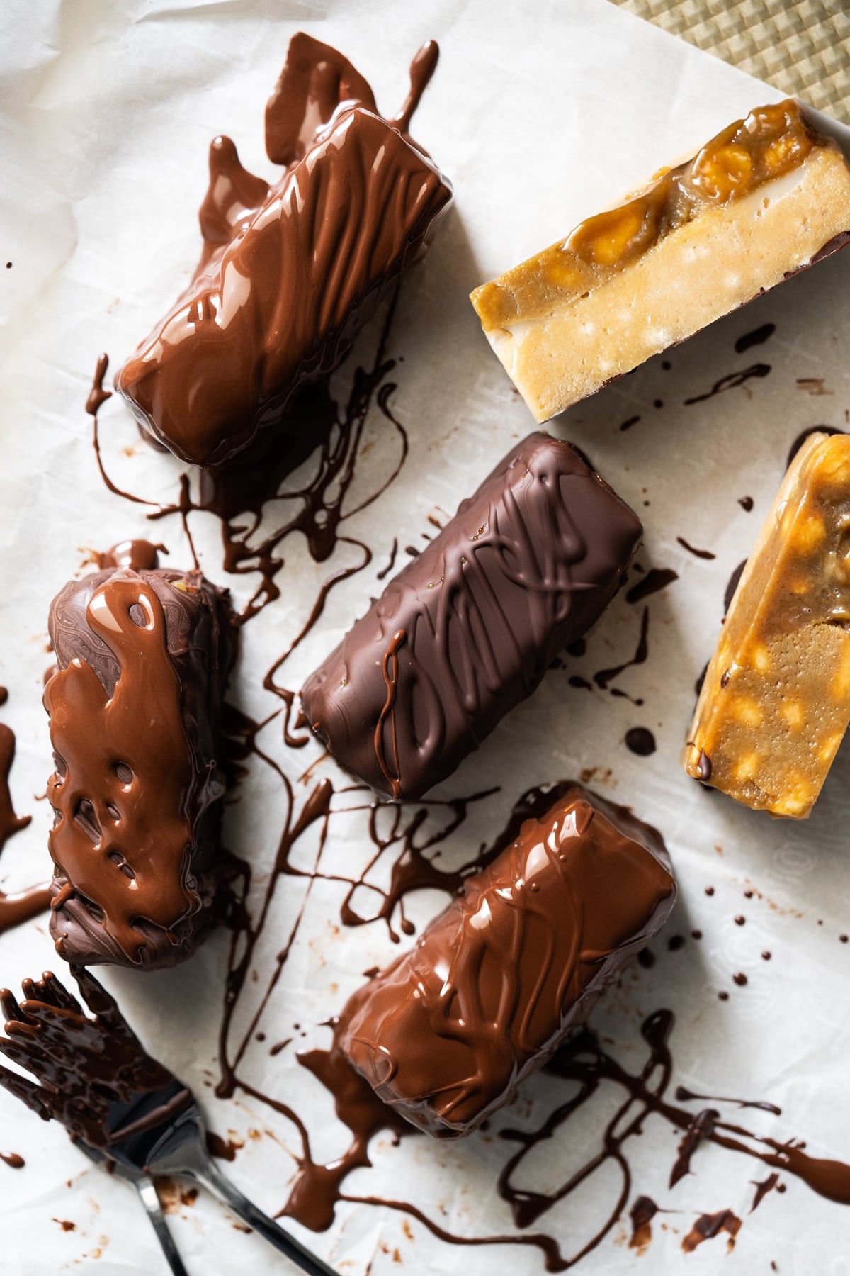 Drizzling melted chocolate onto keto snickers candy bars