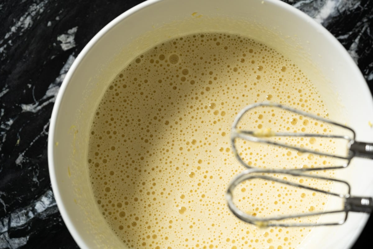 Whisking the eggs with the sweetener and lemon zest until light and fluffy