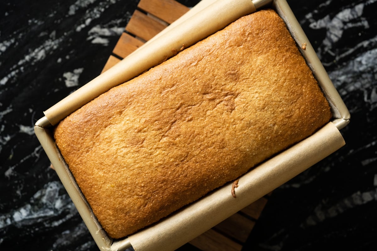 Freshly baked keto lemon pound cake on a wooden rack