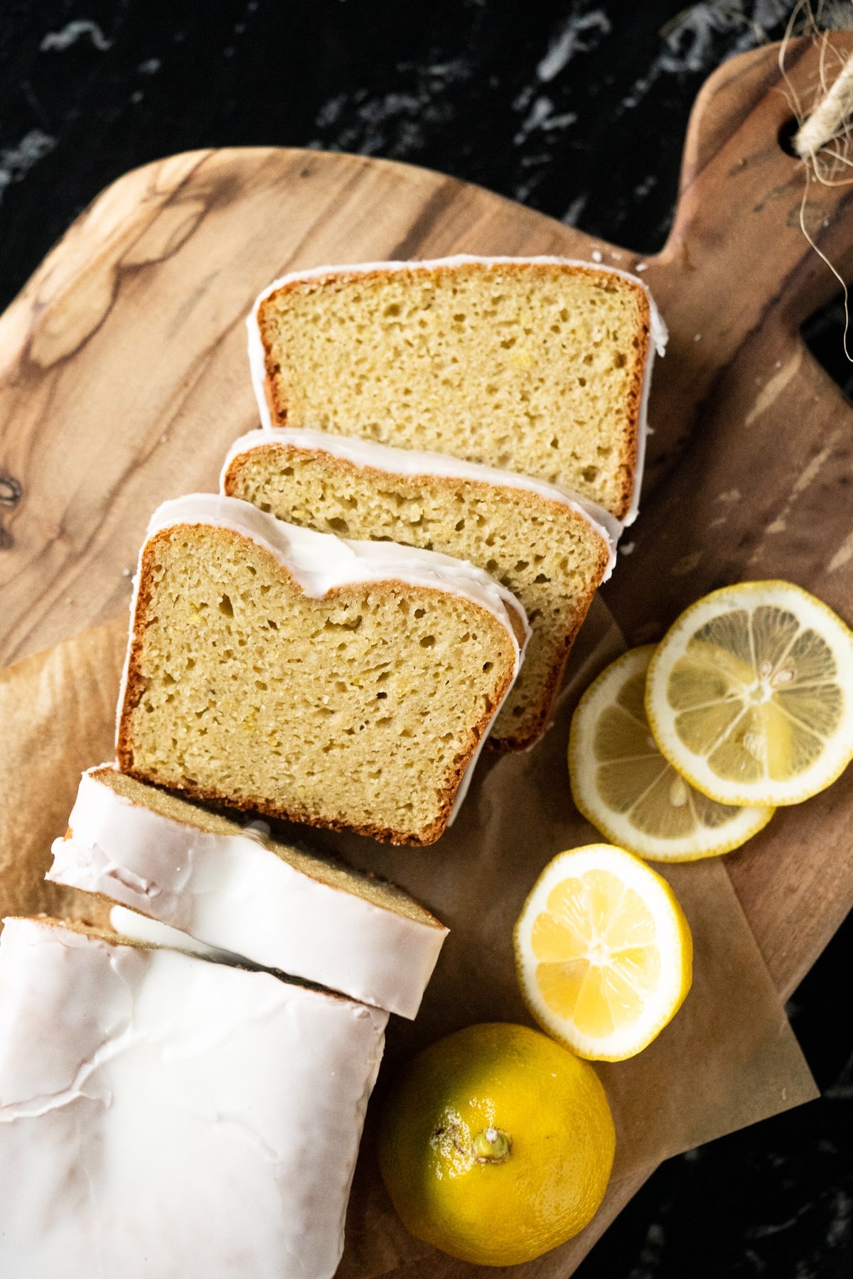 Three slices of iced keto lemon pound cake on a wooden board
