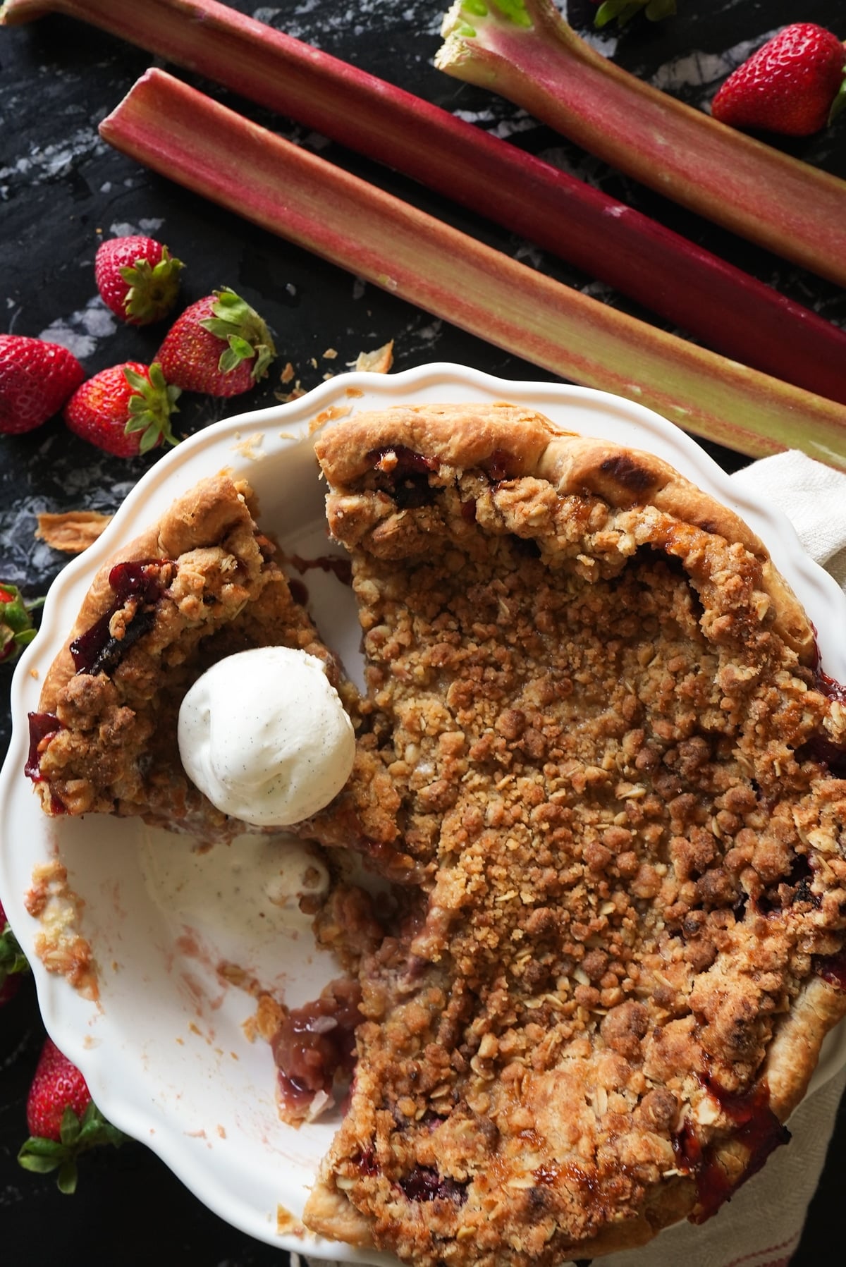 Keto strawberry rhubarb crumble topped with a scoop of vanilla ice cream